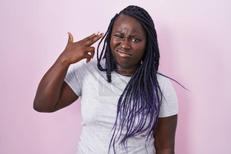 Photo for Young african woman standing over pink background shooting and killing oneself pointing hand and fingers to head like gun, suicide gesture. - Royalty Free Image