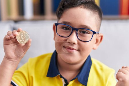 Photo for Young hispanic kid holding tron cryptocurrency coin screaming proud, celebrating victory and success very excited with raised arm - Royalty Free Image