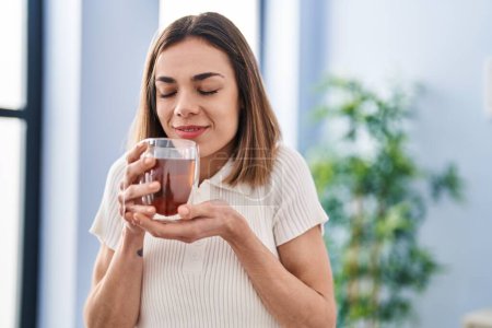 Photo for Young beautiful hispanic woman smiling confident smelling tea at home - Royalty Free Image