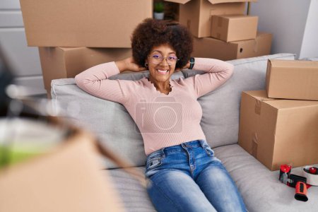 Photo for African american woman smiling confident relaxed on sofa at new home - Royalty Free Image