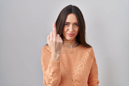 Téléchargez les photos : Young brunette woman standing over white background showing middle finger, impolite and rude fuck off expression - en image libre de droit
