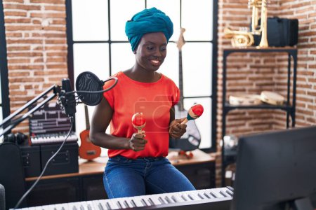 Téléchargez les photos : Jeune musicienne afro-américaine jouant des maracas à la musique - en image libre de droit