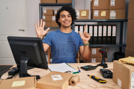 Foto de Hombre hispano con el pelo rizado trabajando en el comercio electrónico de pequeñas empresas mostrando y señalando con los dedos número siete mientras sonríe confiado y feliz. - Imagen libre de derechos