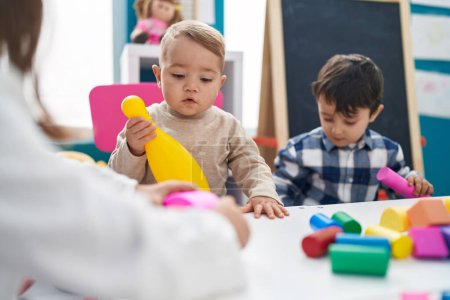 Photo for Adorable boys playing with construction blocks holding bowling pin at kindergarten - Royalty Free Image