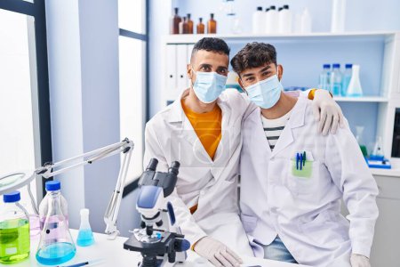 Téléchargez les photos : Deux hommes scientifiques portant un masque médical au laboratoire - en image libre de droit