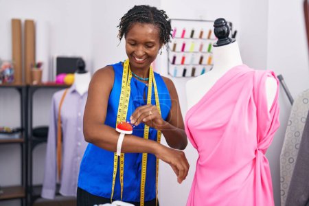 Photo for Middle age african american woman tailor smiling confident sewing dress at atelier - Royalty Free Image