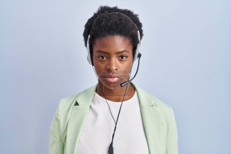 Photo for African american woman wearing call center agent headset relaxed with serious expression on face. simple and natural looking at the camera. - Royalty Free Image
