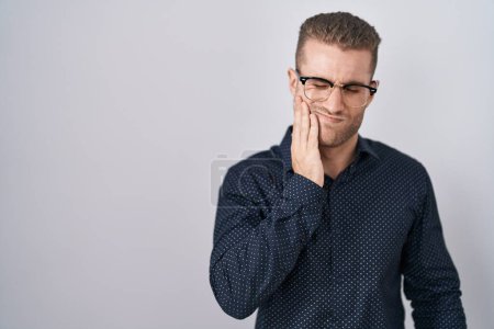 Photo for Young caucasian man standing over isolated background touching mouth with hand with painful expression because of toothache or dental illness on teeth. dentist - Royalty Free Image