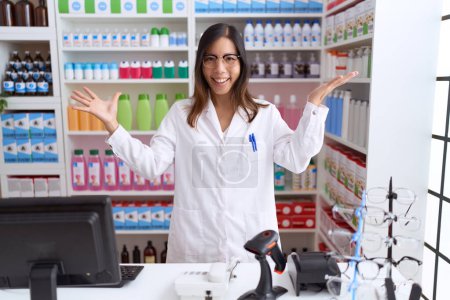 Photo for Middle age chinese woman working at pharmacy drugstore celebrating victory with happy smile and winner expression with raised hands - Royalty Free Image
