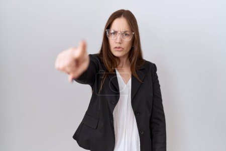 Téléchargez les photos : Belle femme brune portant une veste d'affaires et des lunettes pointant mécontent et frustré vers la caméra, en colère et furieux contre vous - en image libre de droit