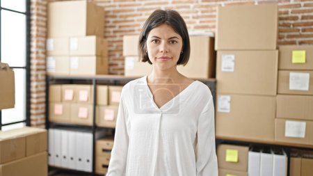 Photo for Young beautiful hispanic woman ecommerce business worker standing with relaxed expression at office - Royalty Free Image