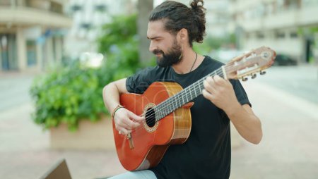Téléchargez les photos : Young hispanic man musician playing classical guitar at park - en image libre de droit