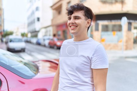 Téléchargez les photos : Homme non binaire souriant confiant regardant du côté de la rue - en image libre de droit