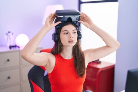Téléchargez les photos : Jeune femme caucasienne streamer portant des lunettes de réalité virtuelle à la salle de jeu - en image libre de droit