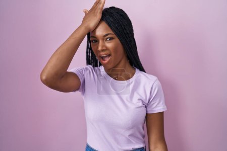 Photo for African american woman with braids standing over pink background surprised with hand on head for mistake, remember error. forgot, bad memory concept. - Royalty Free Image