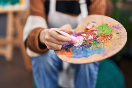 Téléchargez les photos : Jeune artiste mêlant couleurs sur palette au studio d'art - en image libre de droit