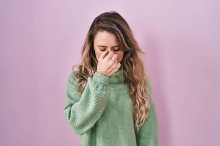 Photo for Young caucasian woman standing over pink background tired rubbing nose and eyes feeling fatigue and headache. stress and frustration concept. - Royalty Free Image