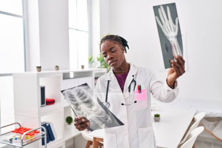 Foto de Mujer afroamericana vistiendo uniforme médico buscando rayos X en la clínica - Imagen libre de derechos