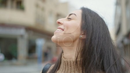 Téléchargez les photos : Young beautiful hispanic woman breathing with closed eyes at street - en image libre de droit