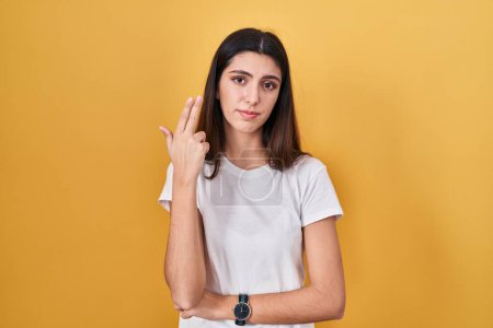 Photo for Young beautiful woman standing over yellow background shooting and killing oneself pointing hand and fingers to head like gun, suicide gesture. - Royalty Free Image