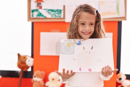 Photo for Adorable hispanic girl preschool student showing draw at kindergarten - Royalty Free Image