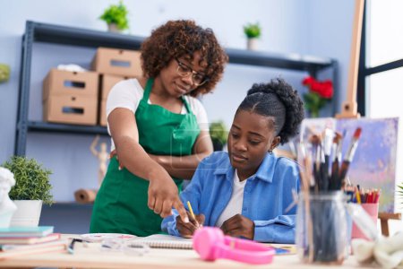 Photo for African american women teacher and student artist drawing on notebook at art studio - Royalty Free Image