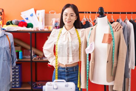 Téléchargez les photos : Young chinese woman tailor smiling confident leaning on manikin at atelier - en image libre de droit