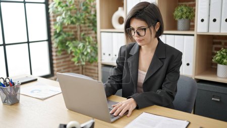 Téléchargez les photos : Jeune femme caucasienne travailleur d'affaires en utilisant un ordinateur portable travaillant au bureau - en image libre de droit