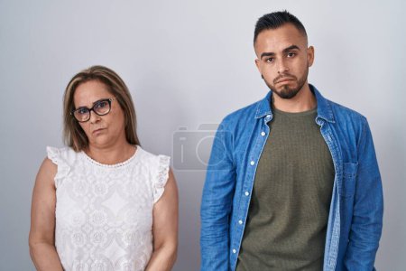 Photo for Hispanic mother and son standing together depressed and worry for distress, crying angry and afraid. sad expression. - Royalty Free Image