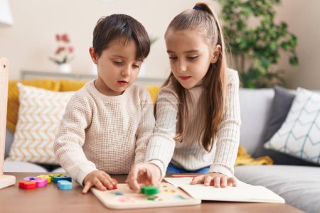 Téléchargez les photos : Adorable garçon et fille jouer avec des mathématiques jeu de puzzle debout à la maison - en image libre de droit