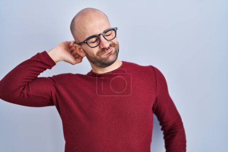 Photo for Young bald man with beard standing over white background wearing glasses stretching back, tired and relaxed, sleepy and yawning for early morning - Royalty Free Image