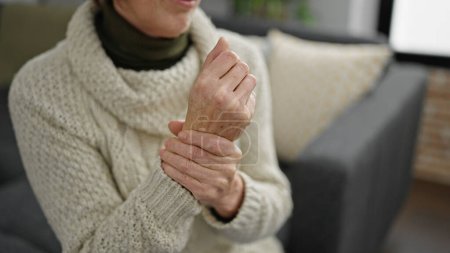 Photo for Mature hispanic woman with wrist pain at home - Royalty Free Image