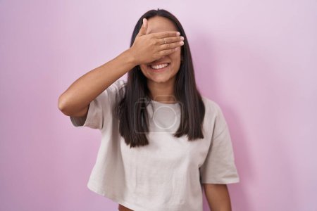 Photo for Young hispanic woman standing over pink background smiling and laughing with hand on face covering eyes for surprise. blind concept. - Royalty Free Image
