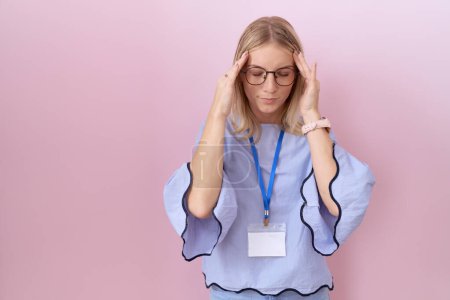 Photo for Young caucasian business woman wearing id card with hand on head, headache because stress. suffering migraine. - Royalty Free Image