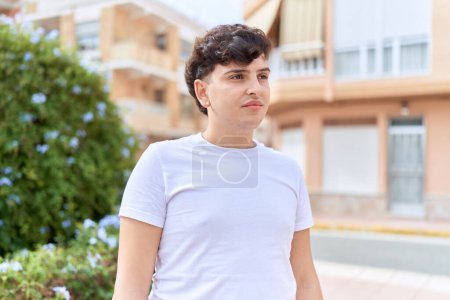 Photo for Non binary man looking to the side with serious expression at park - Royalty Free Image