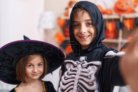 Photo for Adorable boy and girl wearing halloween costume make selfie by camera at home - Royalty Free Image