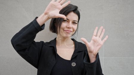 Foto de Joven mujer caucásica sonriendo haciendo gesto de marco con las manos sobre fondo blanco aislado - Imagen libre de derechos