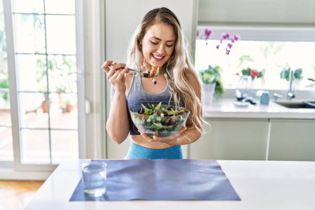 Photo for Young woman smiling confident eating salad at kitchen - Royalty Free Image