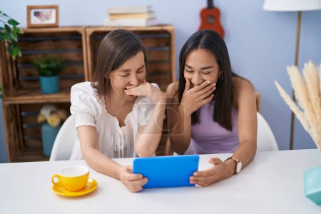 Photo for Two women mother and daughter watching video on touchpad at home - Royalty Free Image