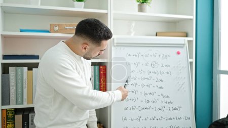 Photo for Young hispanic man teacher teaching maths lesson at library university - Royalty Free Image