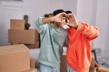Photo for Two man couple doing heart gesture with hands at new home - Royalty Free Image