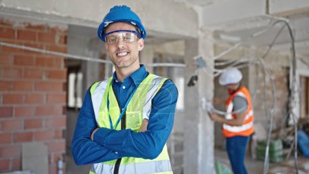 Photo for Two men builders standing with arms crossed gesture working at construction site - Royalty Free Image