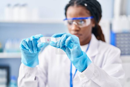 Photo for African american woman scientist holding sample at laboratory - Royalty Free Image