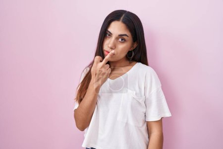 Foto de Young arab woman standing over pink background showing middle finger, impolite and rude fuck off expression - Imagen libre de derechos