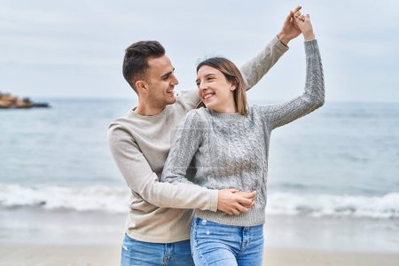 Foto de Man and woman couple smiling confident dancing at seaside - Imagen libre de derechos