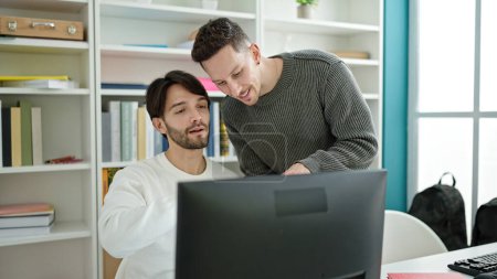 Foto de Dos hombres estudiantes que estudian informática en la universidad de la biblioteca - Imagen libre de derechos