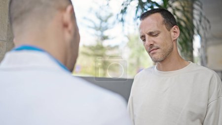Foto de Dos hombres doctor y paciente teniendo consulta médica hablando en el hospital - Imagen libre de derechos
