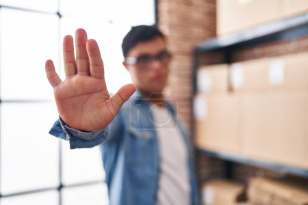 Téléchargez les photos : Homme trisomique ecommerce travailleur d'affaires faisant stop signe avec la main au bureau - en image libre de droit