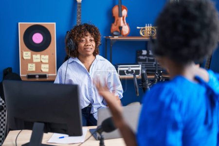 Téléchargez les photos : African american women musicians smiling confident speaking at music studio - en image libre de droit