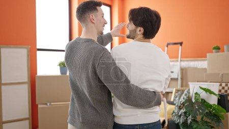 Photo for Two men couple hugging each other speaking at new home - Royalty Free Image